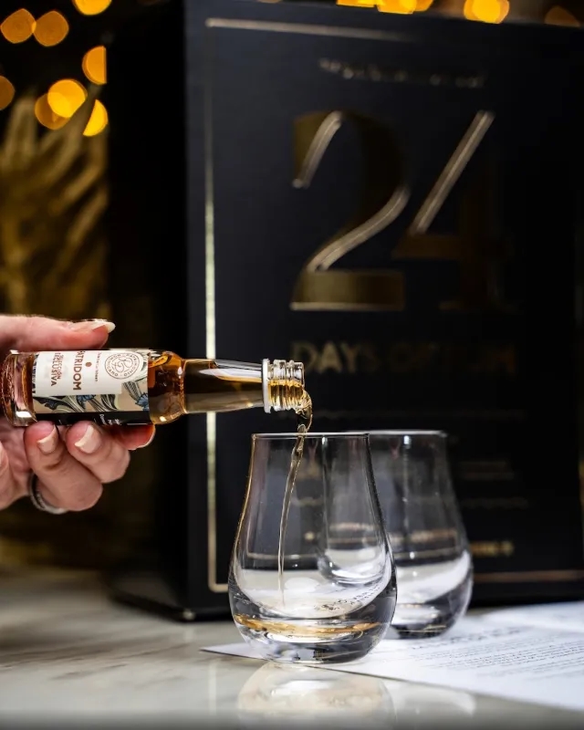 Miniatyrflaska hälls upp i två glas från 24 Days of Rum Black Edition